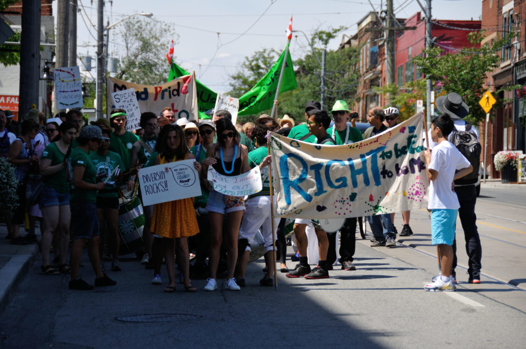 Marchers holding signs marching in the Mad Pride Parade in Toronto 2016